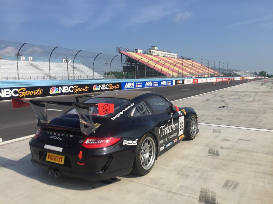Black Porsche 911 GT3 Cup car in pit lane at Watkins Glen