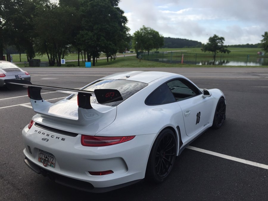 White Porsche 911 GT3 parked in the track paddock