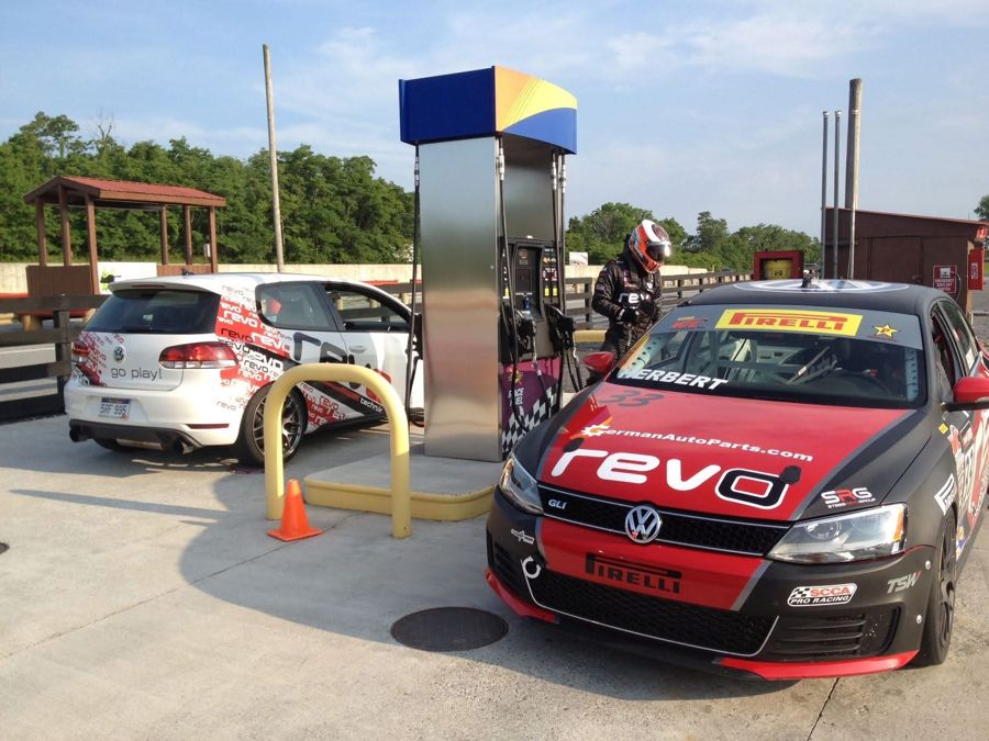 VW Jetta GLI race car at the track fuel pump with a GTI behind