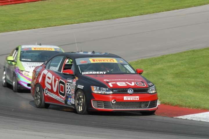 Black Volkswagen Jetta number 33 racing in traffic