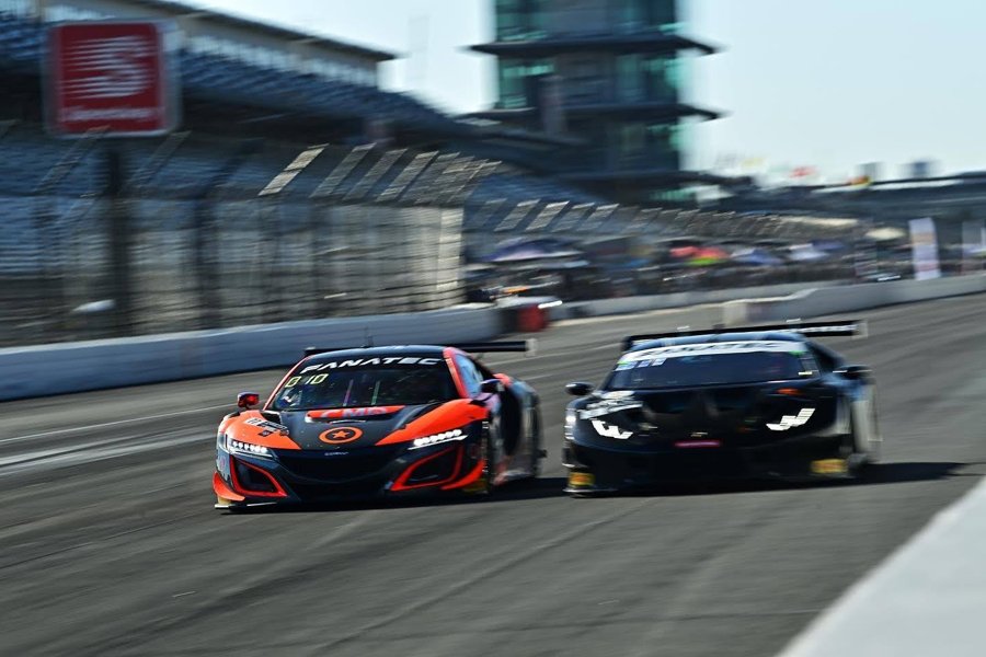 Acura NSX GT3 leading a Lamborghini Huracan GT3 through a corner at Indianapolis Motor Speedway